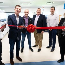 Scientists at the opening of the new MS center cutting a red ribbon. 