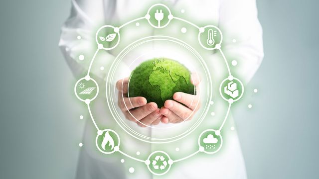 A scientist holds a green globe in both hands. It is surrounded by icons representing areas of sustaibility. 