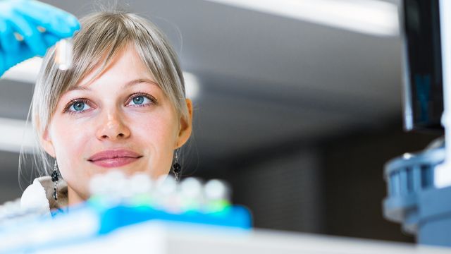 Young female scientist looking at a sample. 