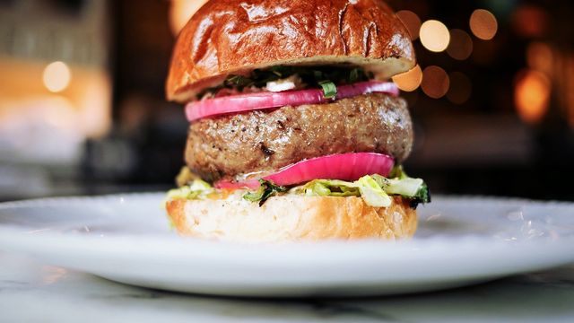 Gourmet beef burger on a white plate. 