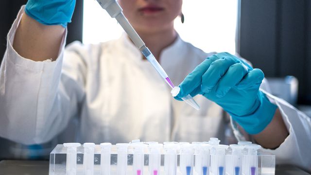 A scientist pipetting into an Eppendorf tube. 