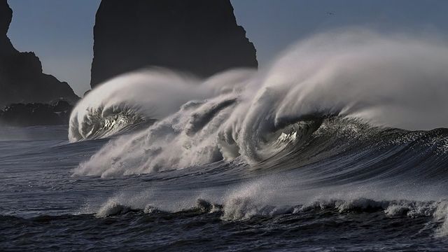 Waves rolling in with lots of spray in the air. 