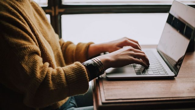 A person types on a laptop. 