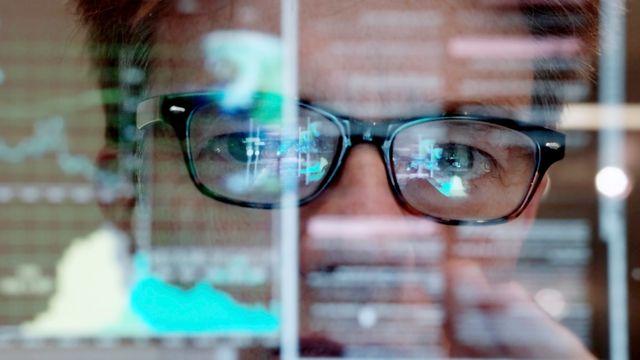 A scientist behind a screen. 