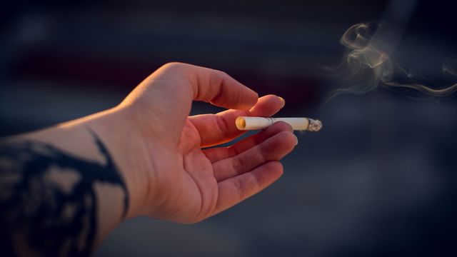 A person holding a cigarette. 