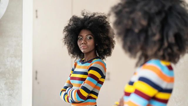 A woman looking at herself in the mirror. 